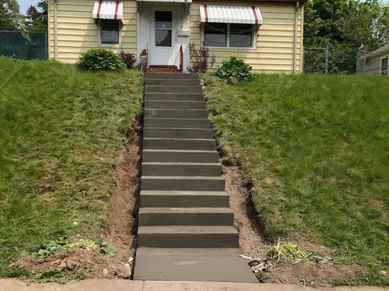 A set of concrete stairs leads up to a house