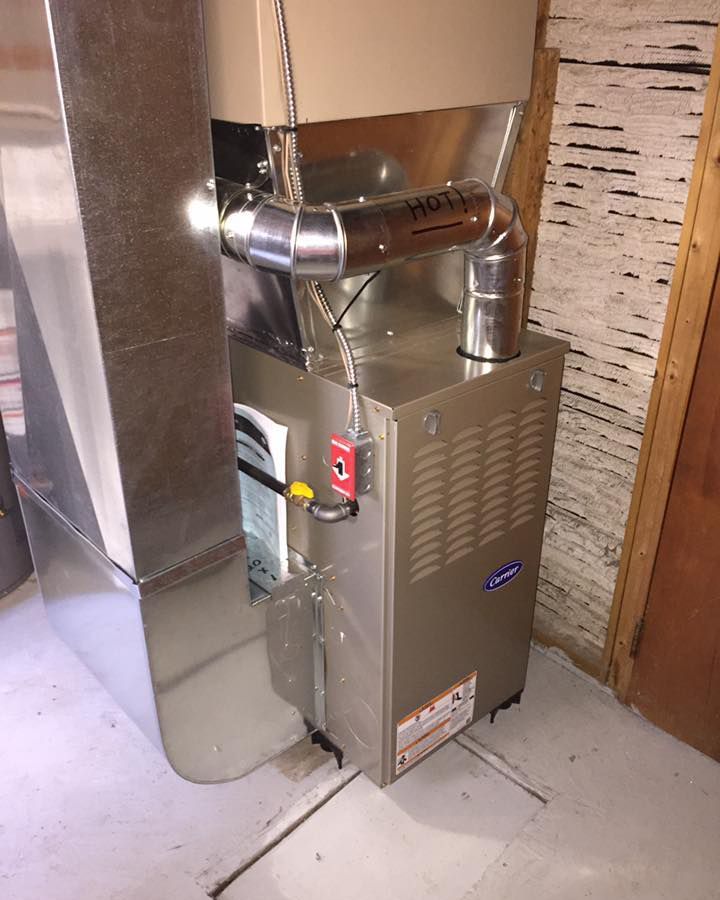 A stainless steel air conditioner is sitting in a room next to a wall.