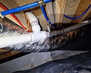 A bunch of pipes are hanging from the ceiling of a house.