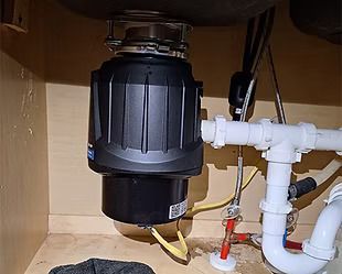 A garbage disposal is sitting under a sink in a kitchen.