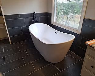 A bathtub is sitting in a bathroom next to a window.