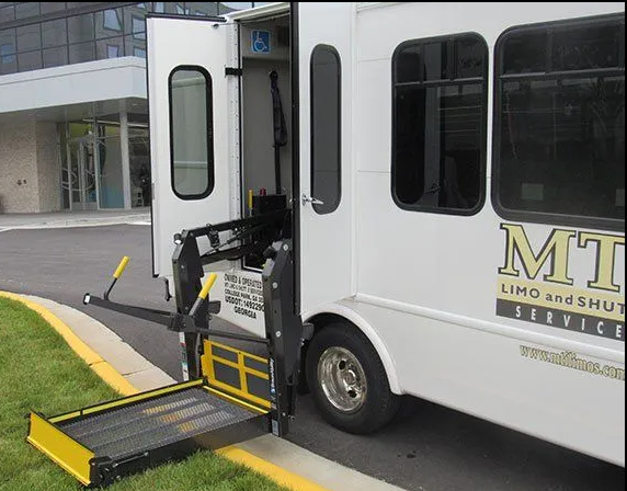 White shuttle bus with wheelchair lift extended.