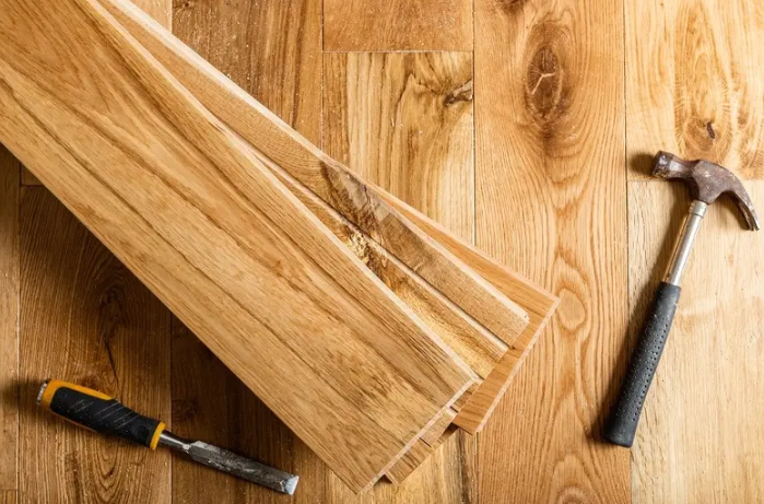 Wooden planks and a hammer with a chisel on a workbench, showing carpentry tools and materials