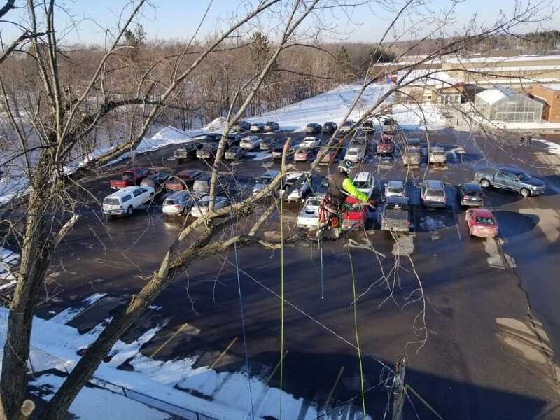 Overhead view of a crowded parking lot with many cars and patches of snow around the edges