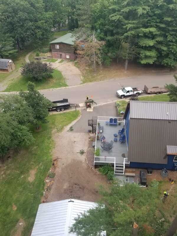 Aerial view of a flooded driveway and road beside a house, with a truck and trees nearby.
