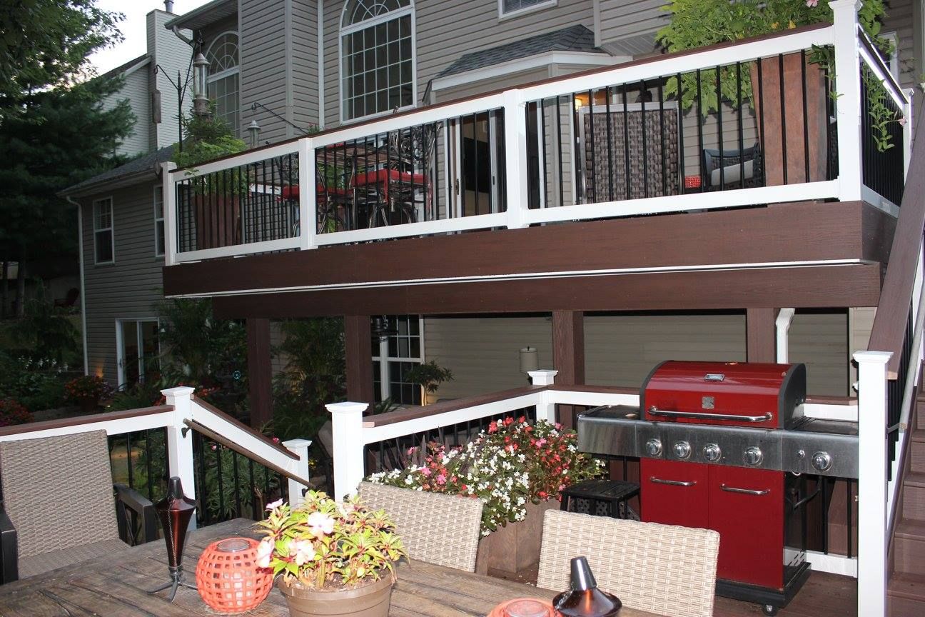 A deck with a table and chairs and a grill