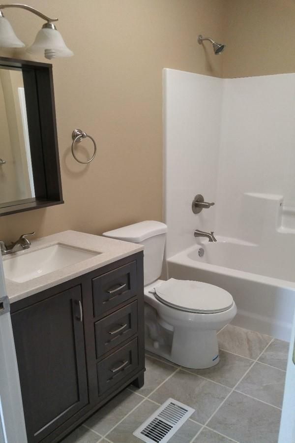A bathroom with a toilet , sink , and bathtub.