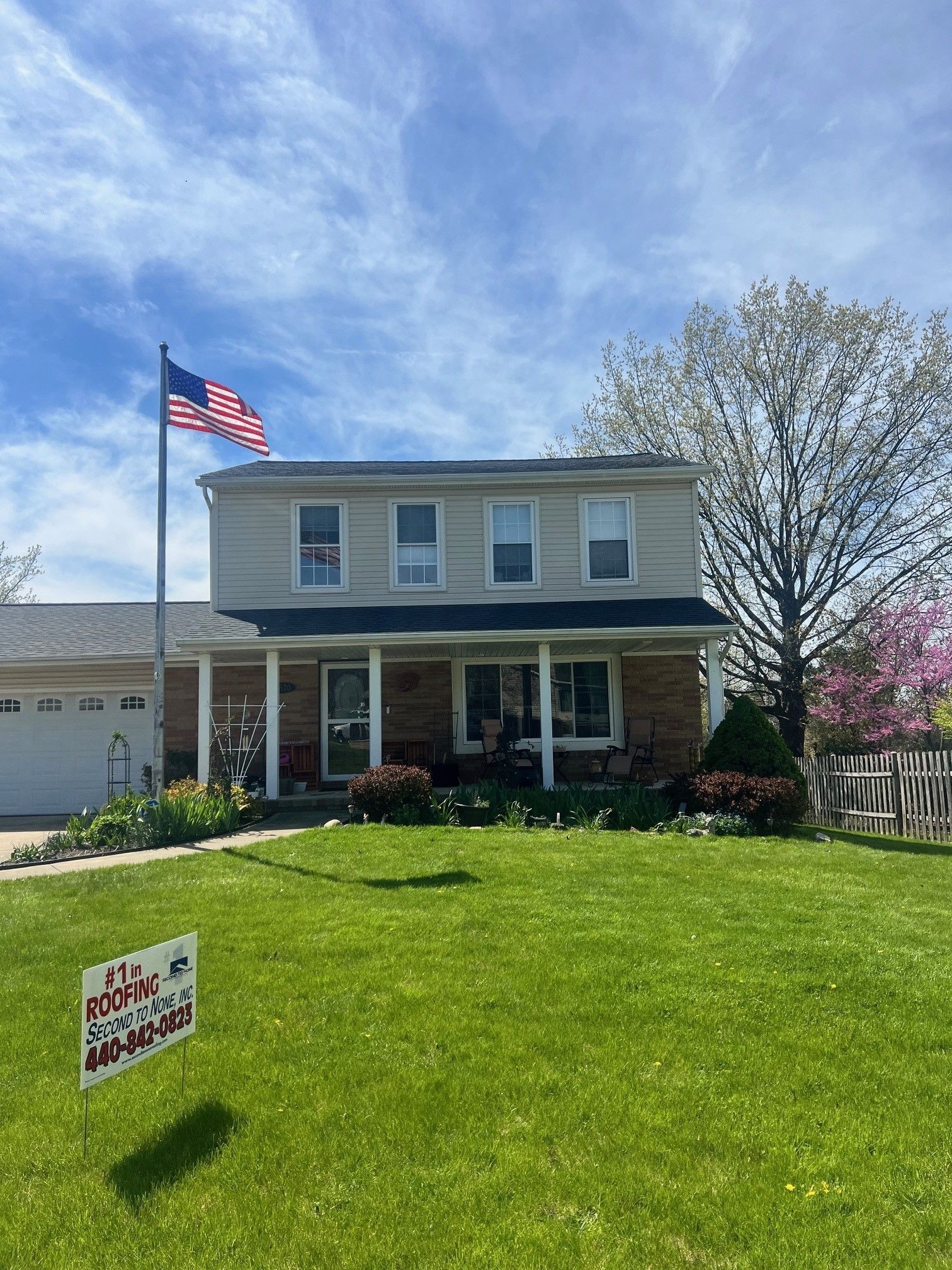 A house with a flag and a sign in front of it.