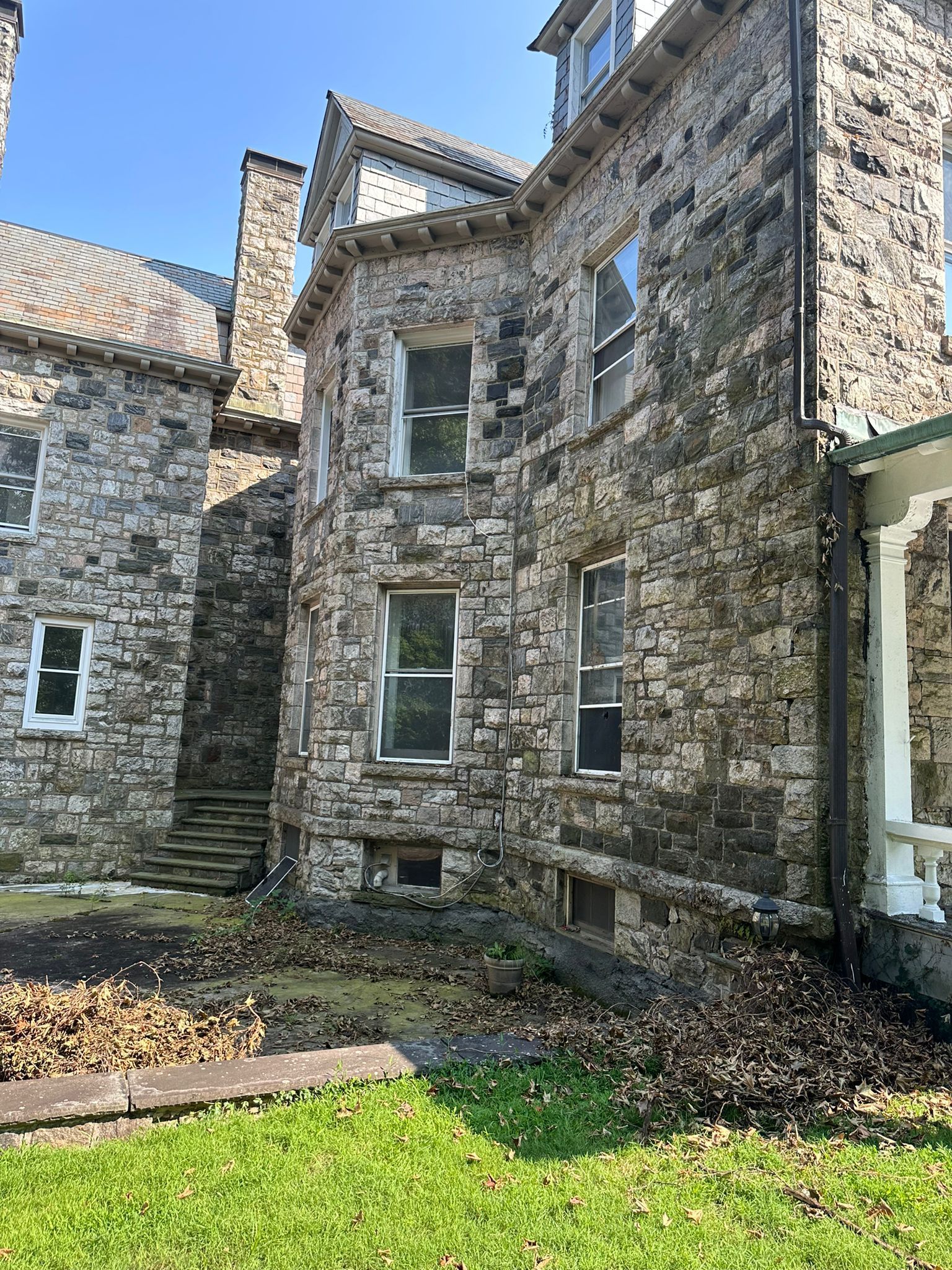 Stone building with windows and a small yard.