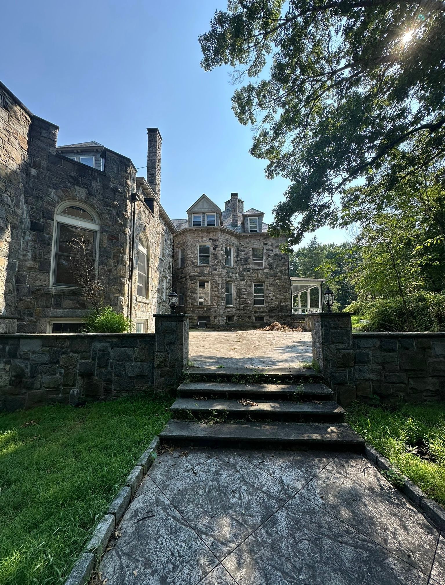 Stone building with steps leading to a doorway, bright sunny day.