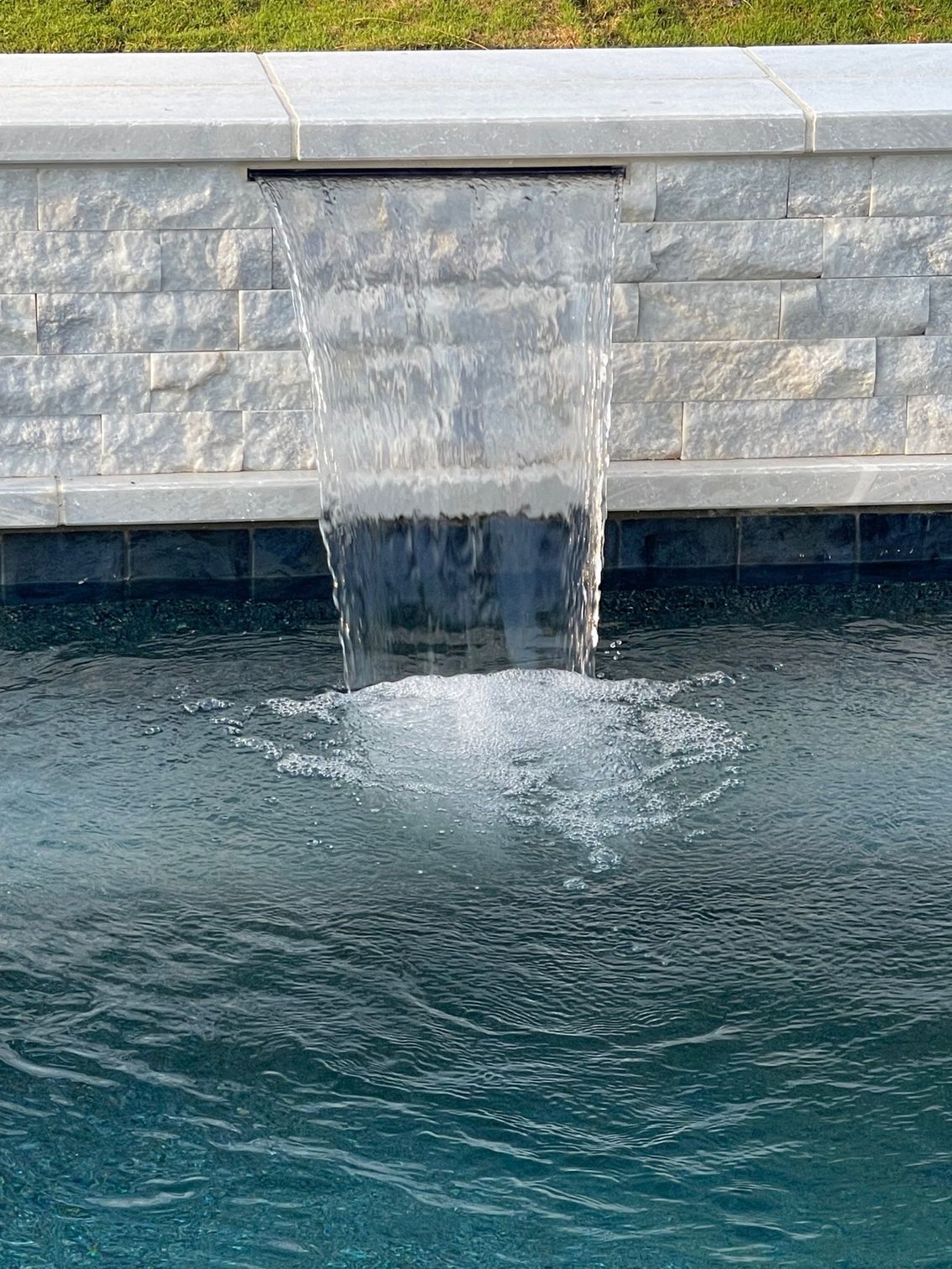 A swimming pool with blue tiles on the edge of it