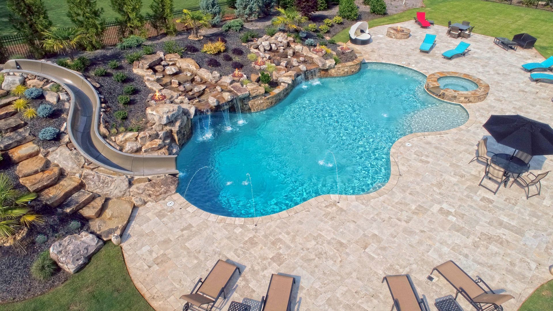 A large swimming pool with a slide in the backyard