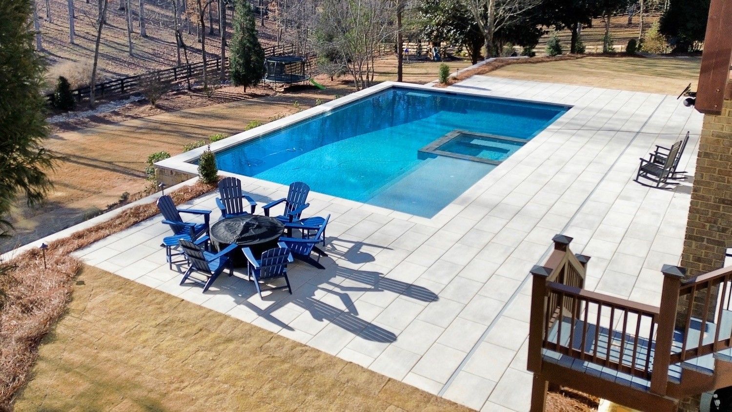 A fire pit with chairs and a heater on a patio.