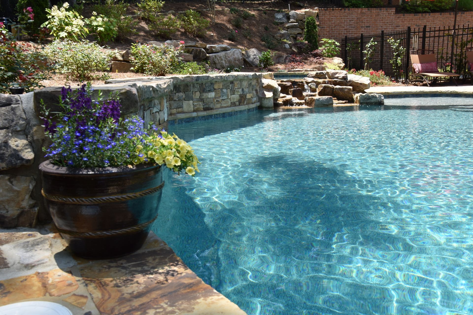 There is a large swimming pool in the backyard of a house.