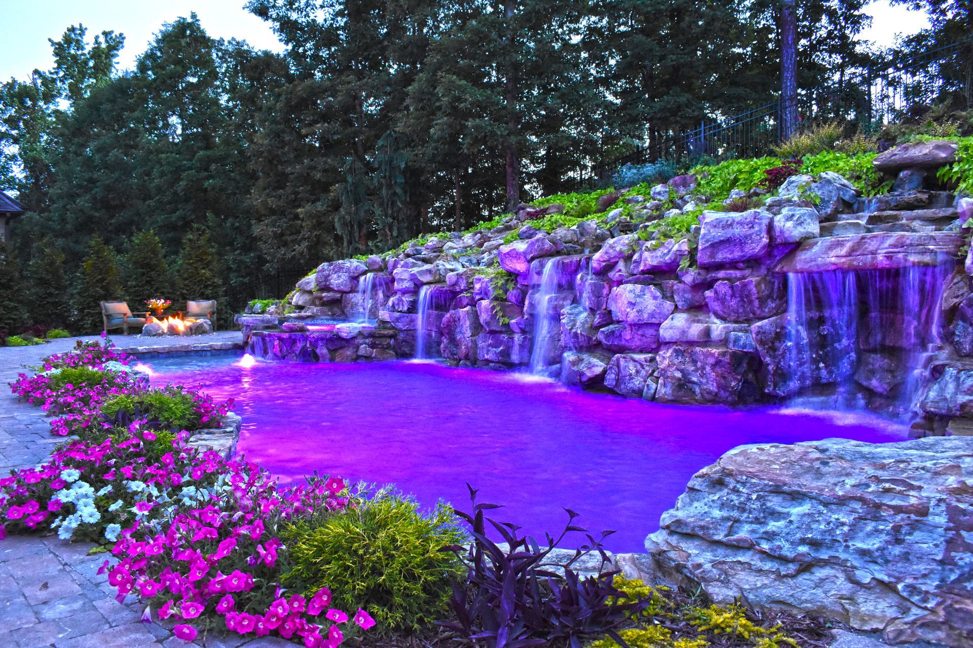 A swimming pool with a fountain in the middle of it