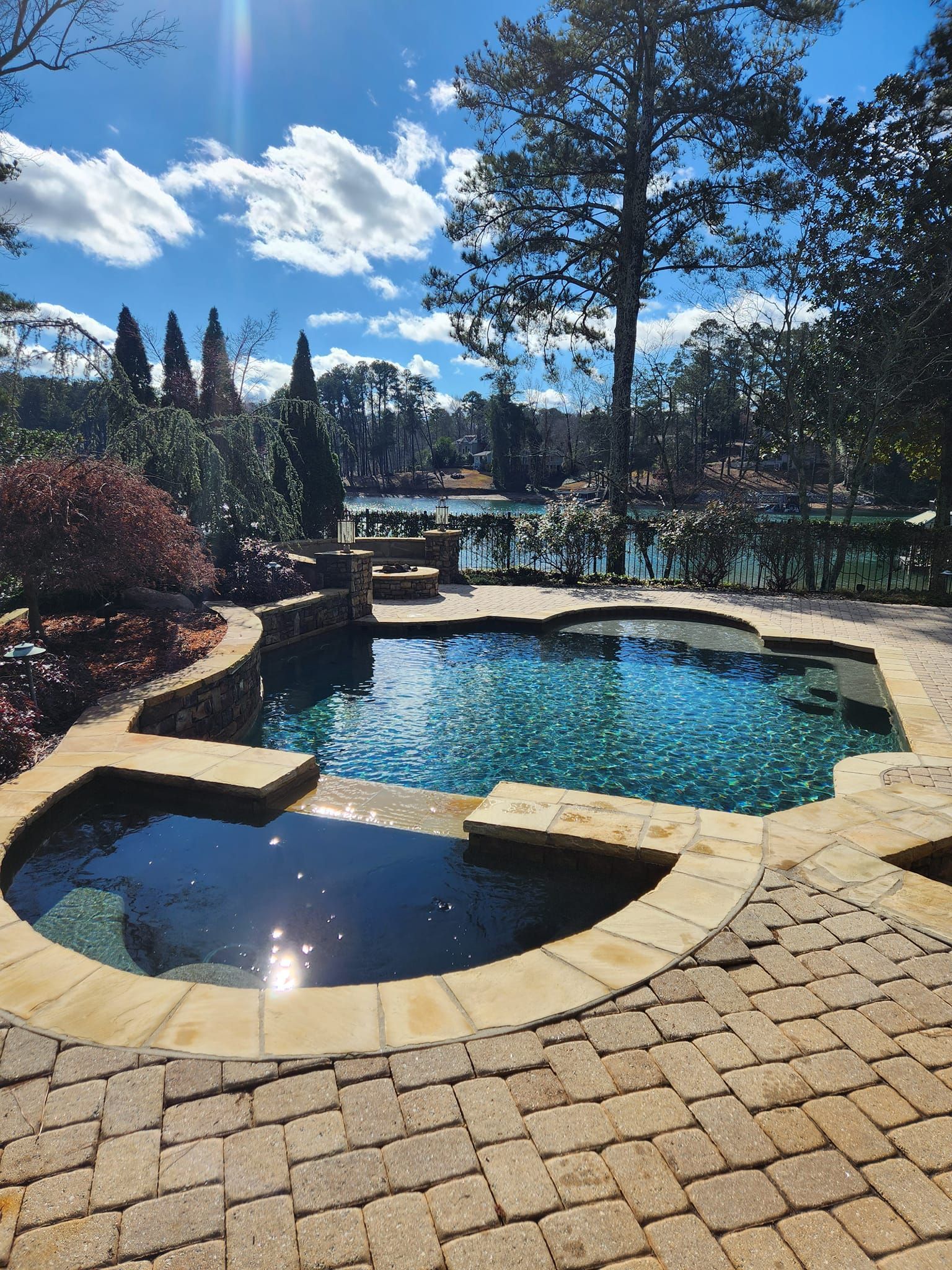 A large swimming pool with a hot tub in the middle of it