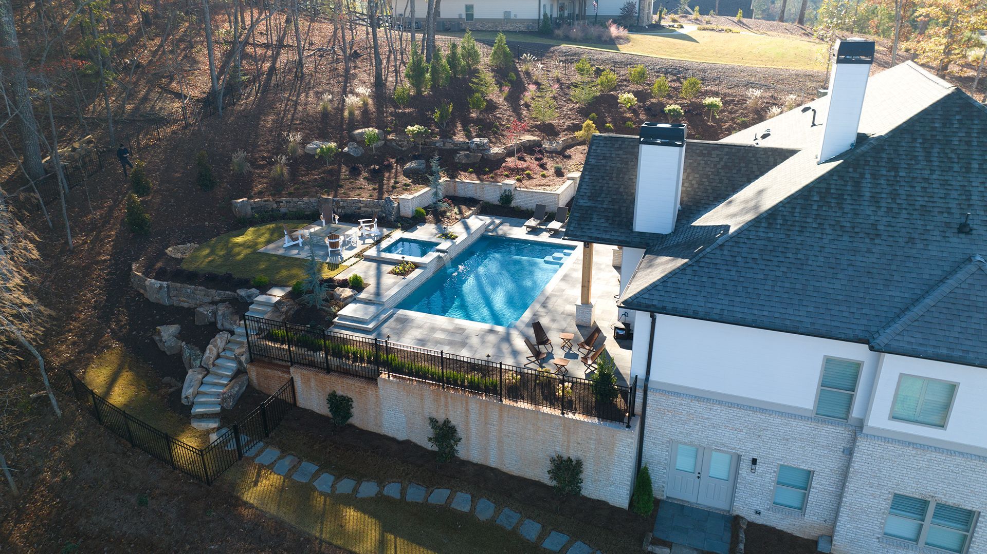Aerial view of a house with a large swimming pool in the backyard