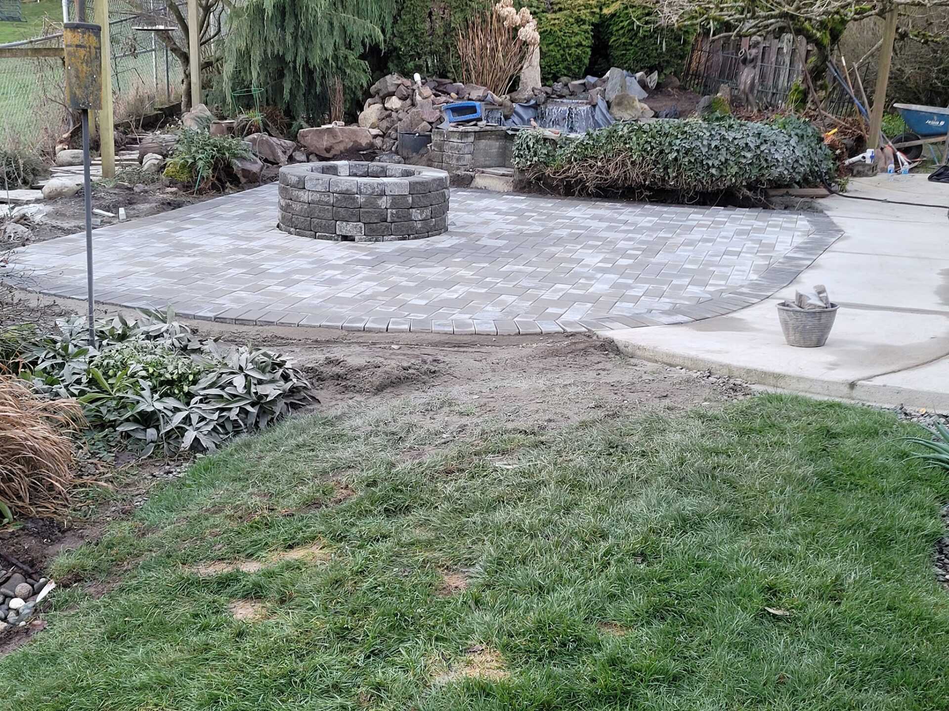 brick paver patio with fire pit in the center