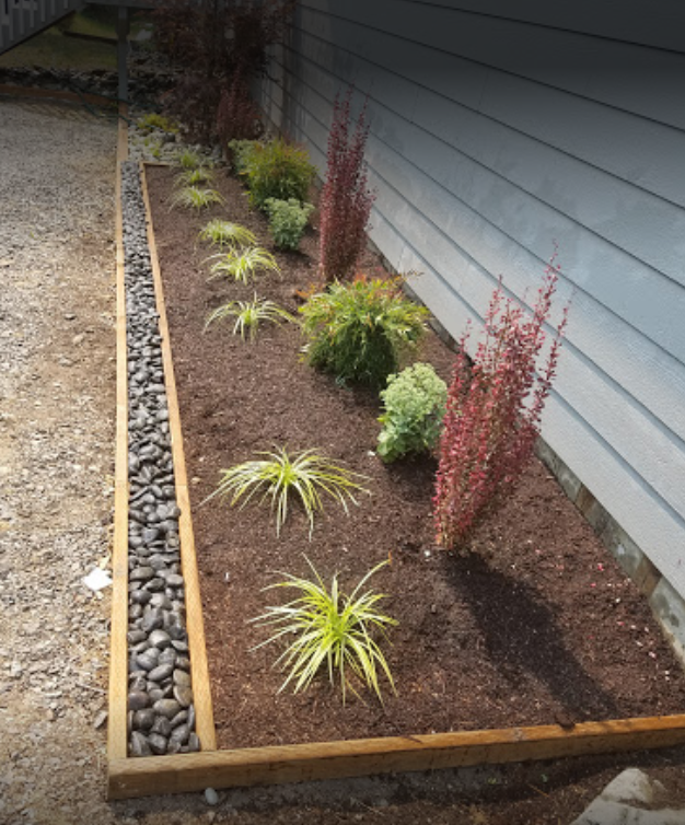 garden bed against house with rock border