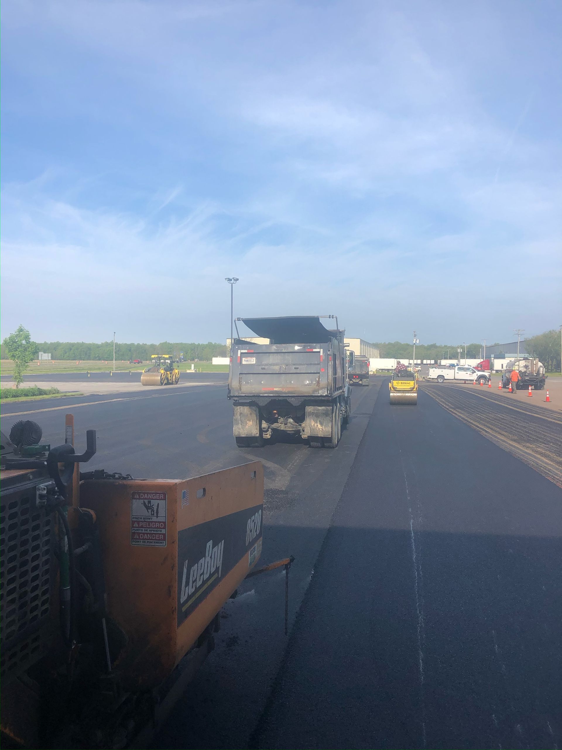 Roadside view of a truck and yellow car on a highway near construction barriers