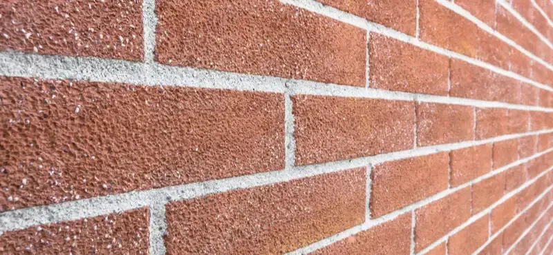 Close-up of a red brick wall with white mortar lines receding into the distance
