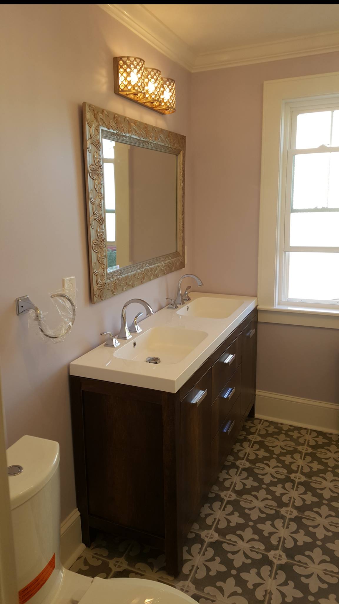A bathroom with two sinks , a toilet , and a mirror.