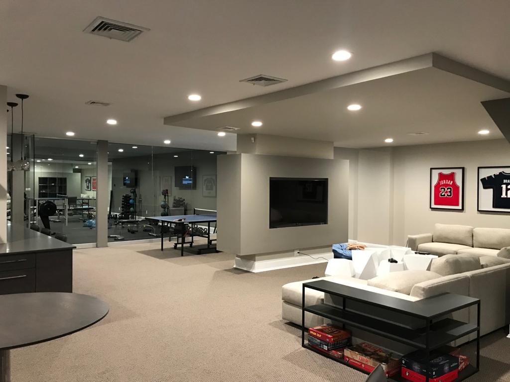 A living room in a basement with a couch and a television.