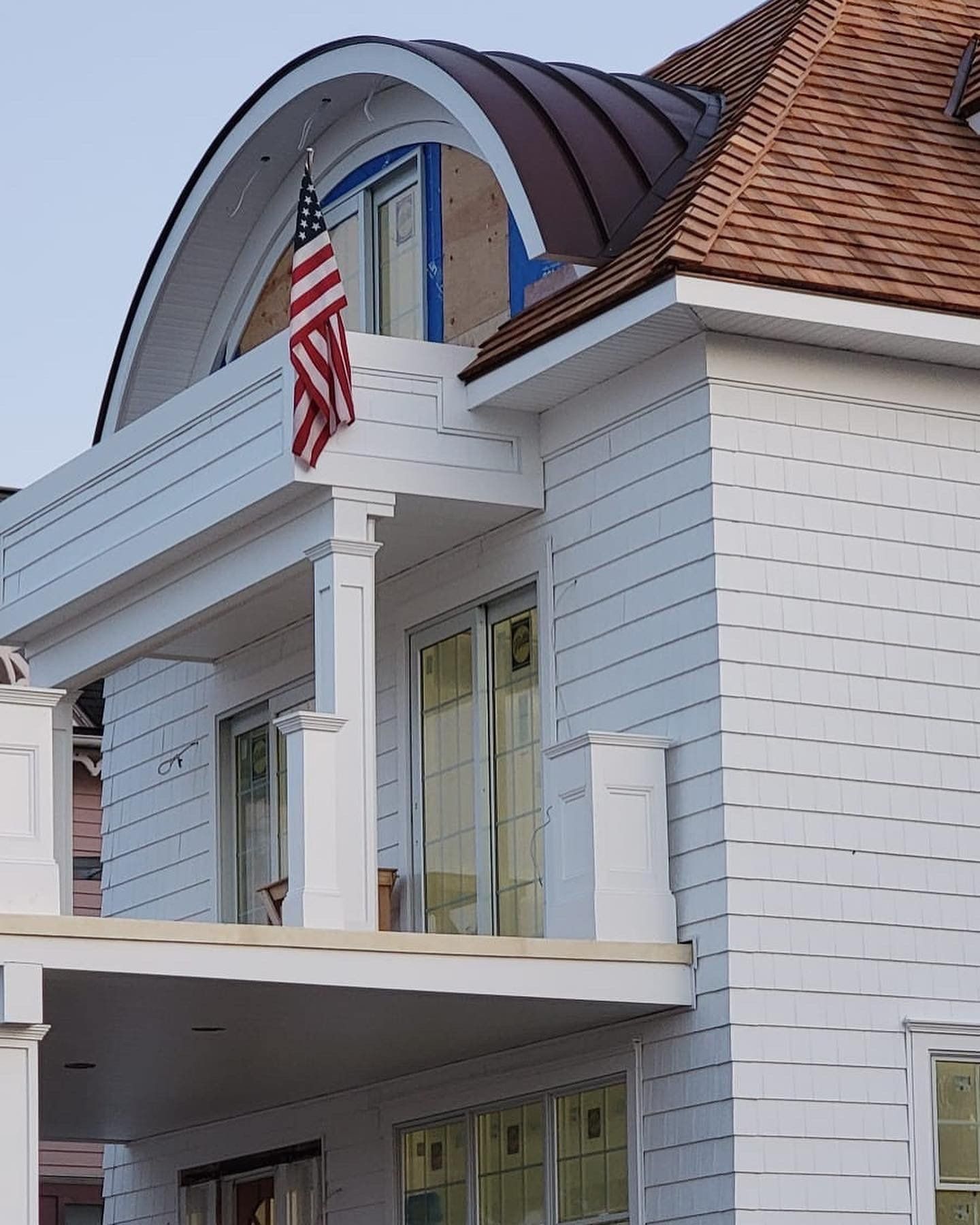 A large white house with an american flag hanging from the roof