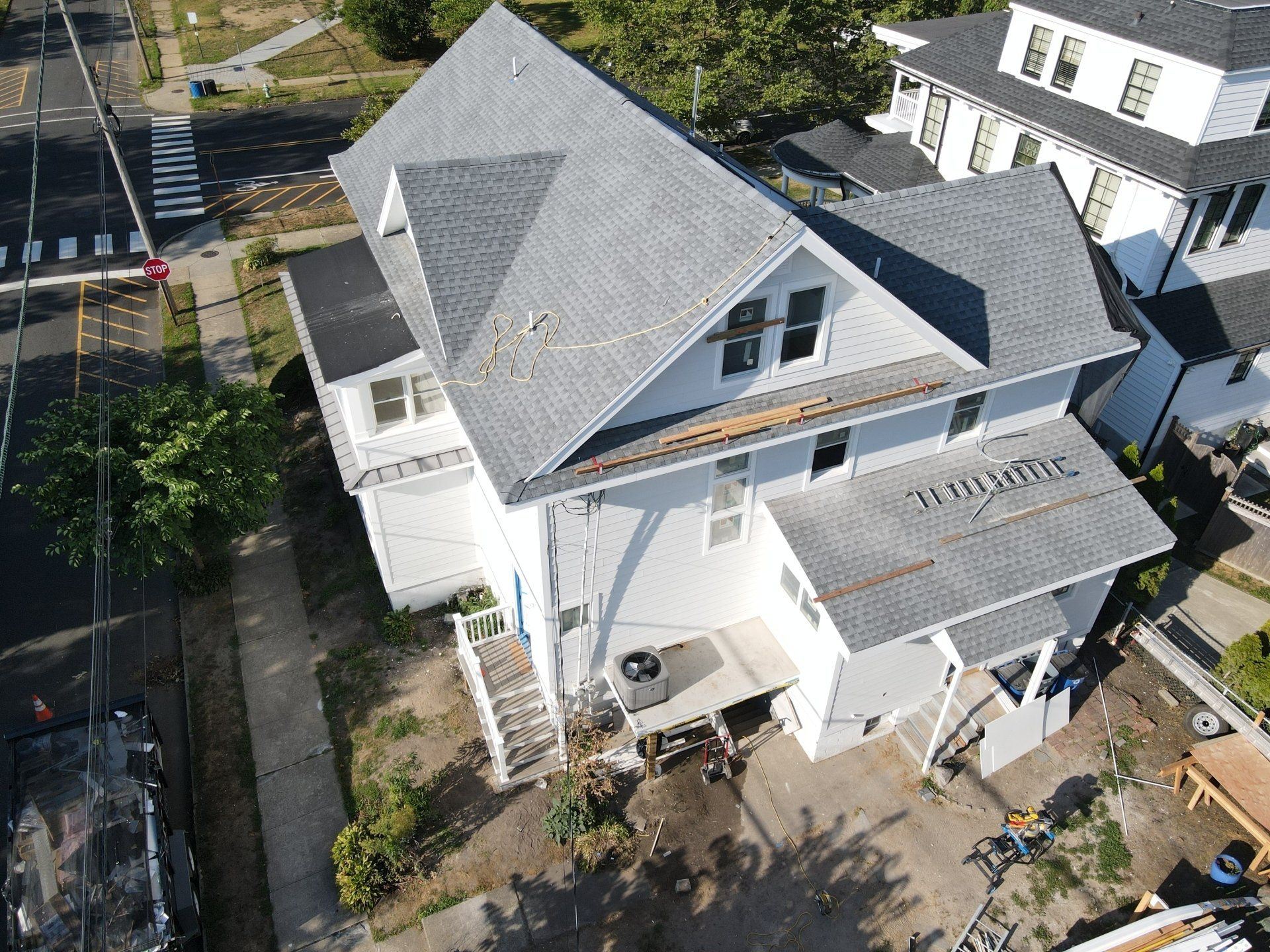 An aerial view of a large white house with a gray roof.
