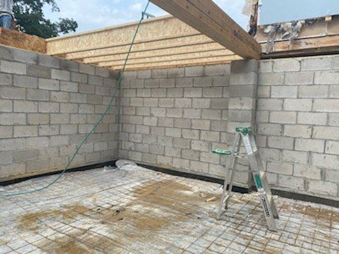 A ladder is sitting in the middle of a room with brick walls.