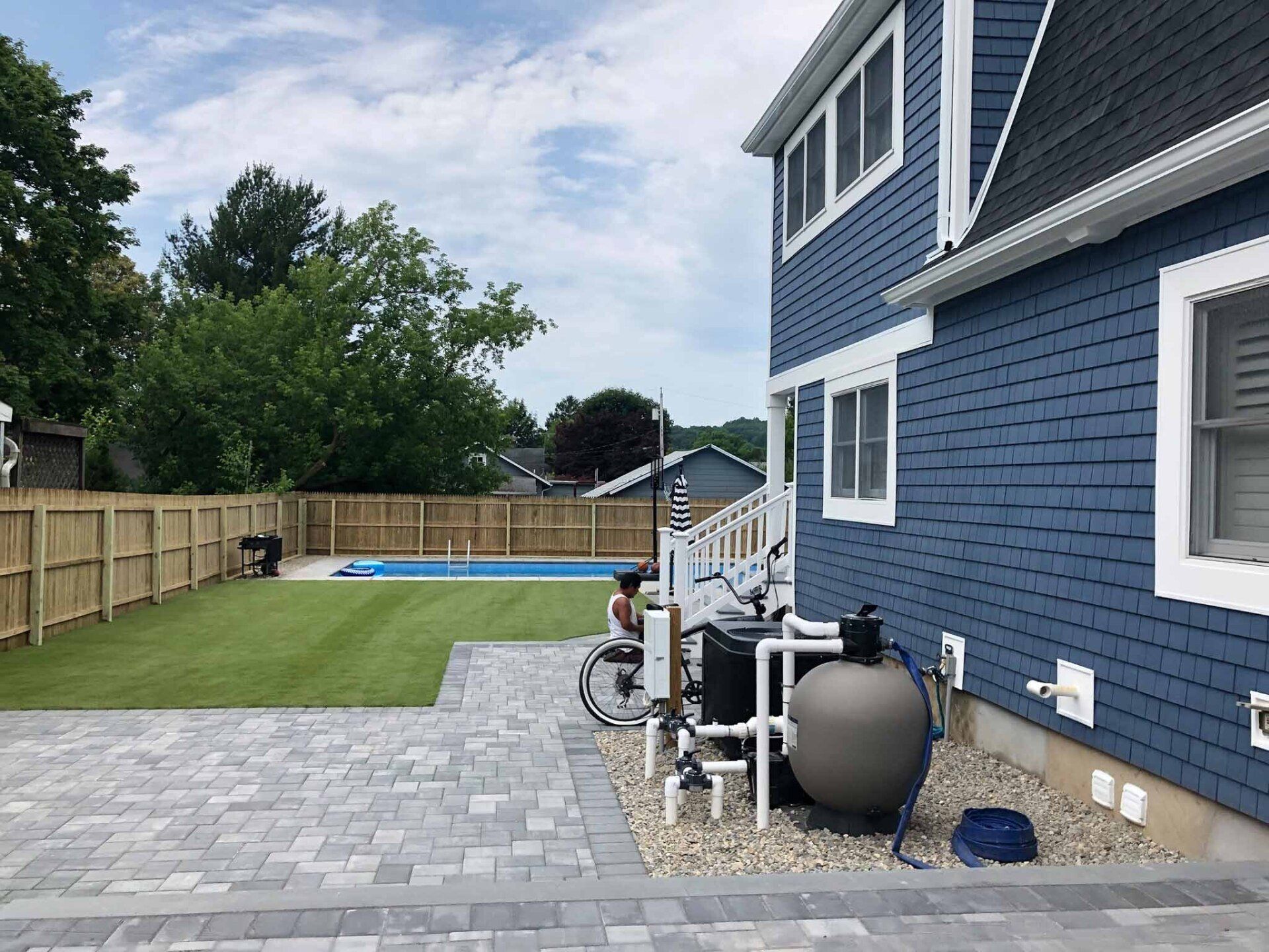 A blue house with a swimming pool in the backyard.
