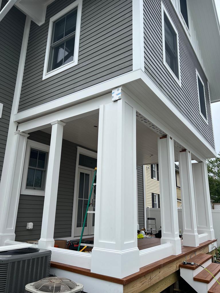A house with a porch and a ladder on the side of it.