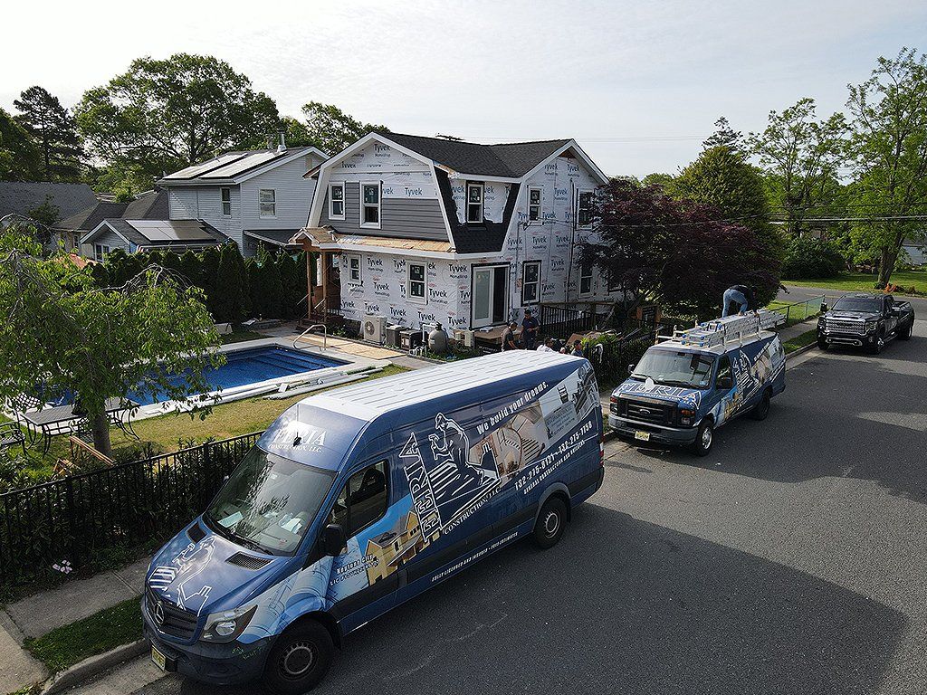 A group of vans are parked in front of a house.