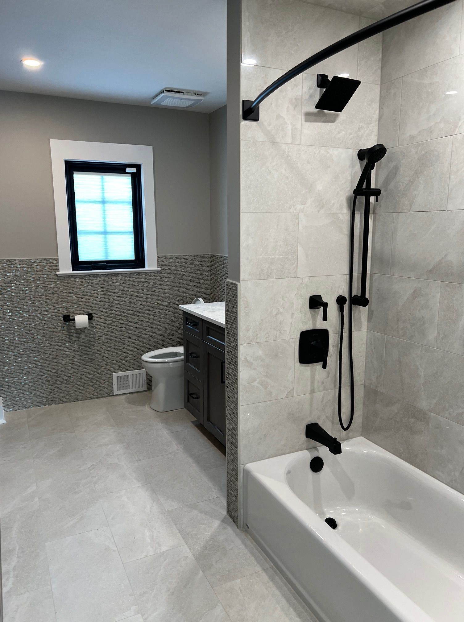 A bathroom with a tub, toilet and shower