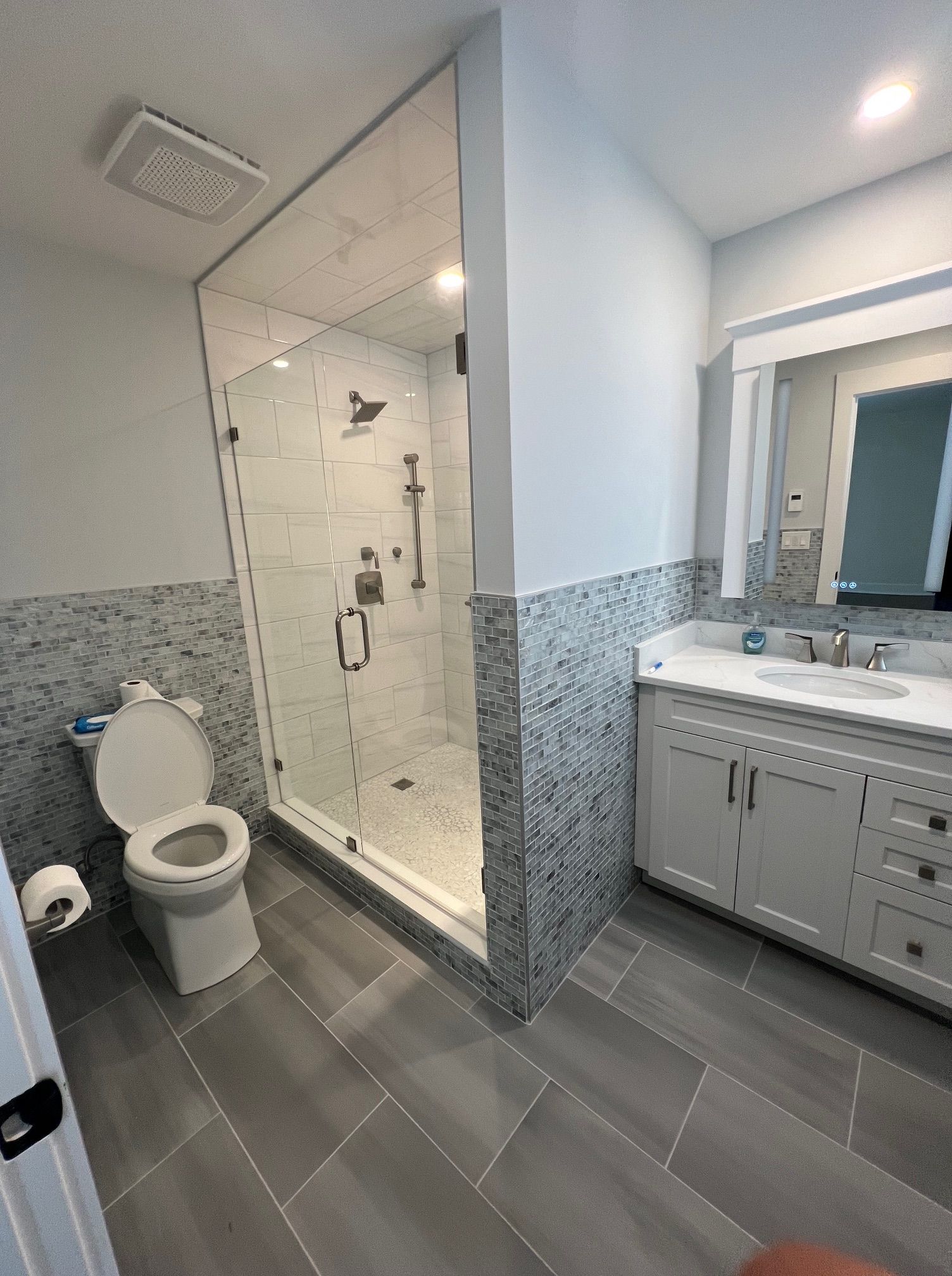 A bathroom with a toilet, sink, and walk in shower