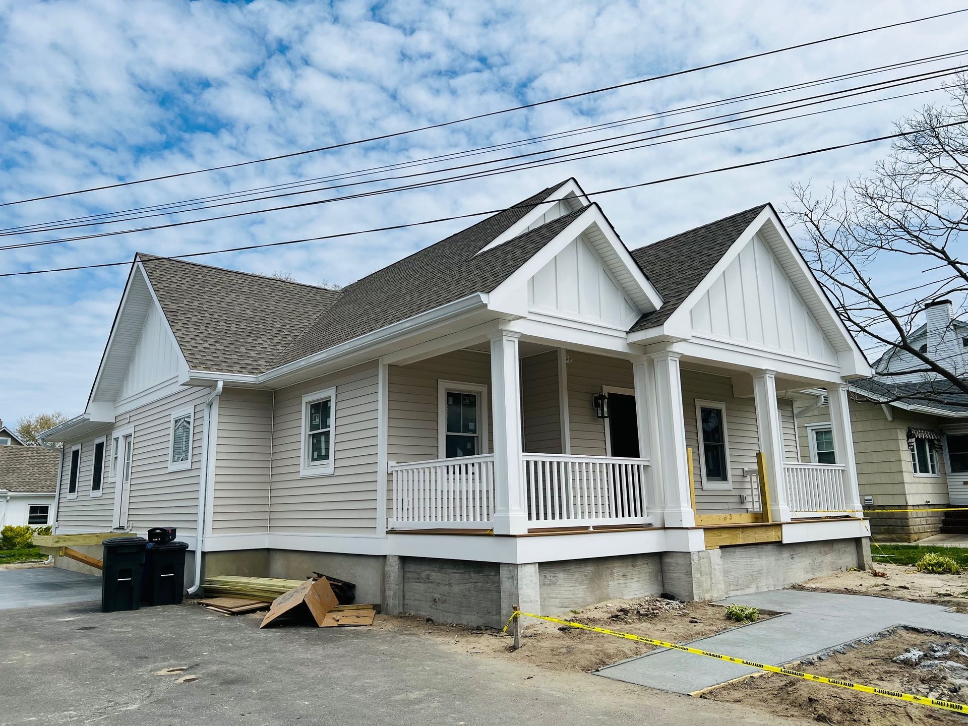 A white house with a porch and a gray roof