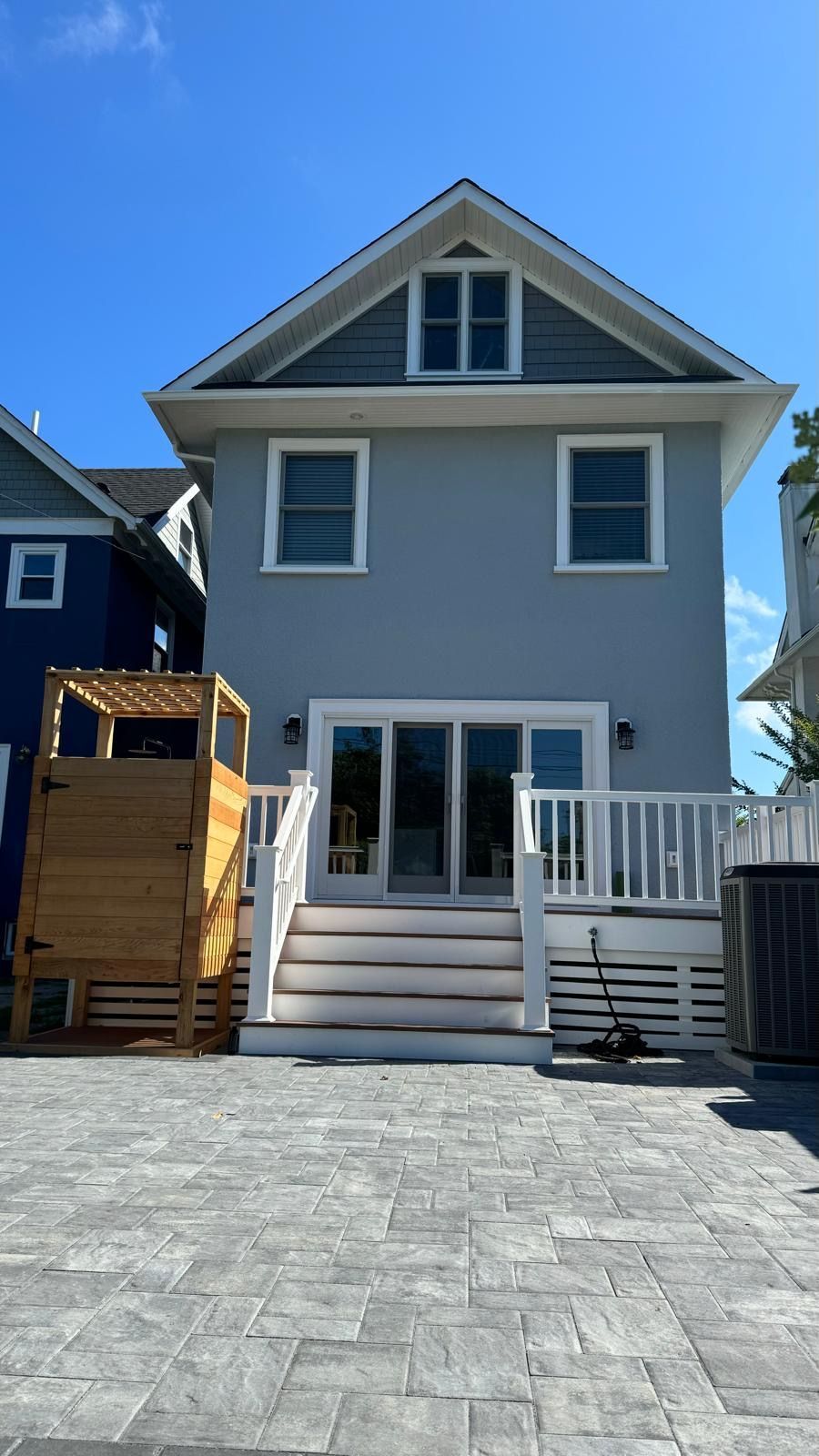 The back of a house with a playground in front of it.