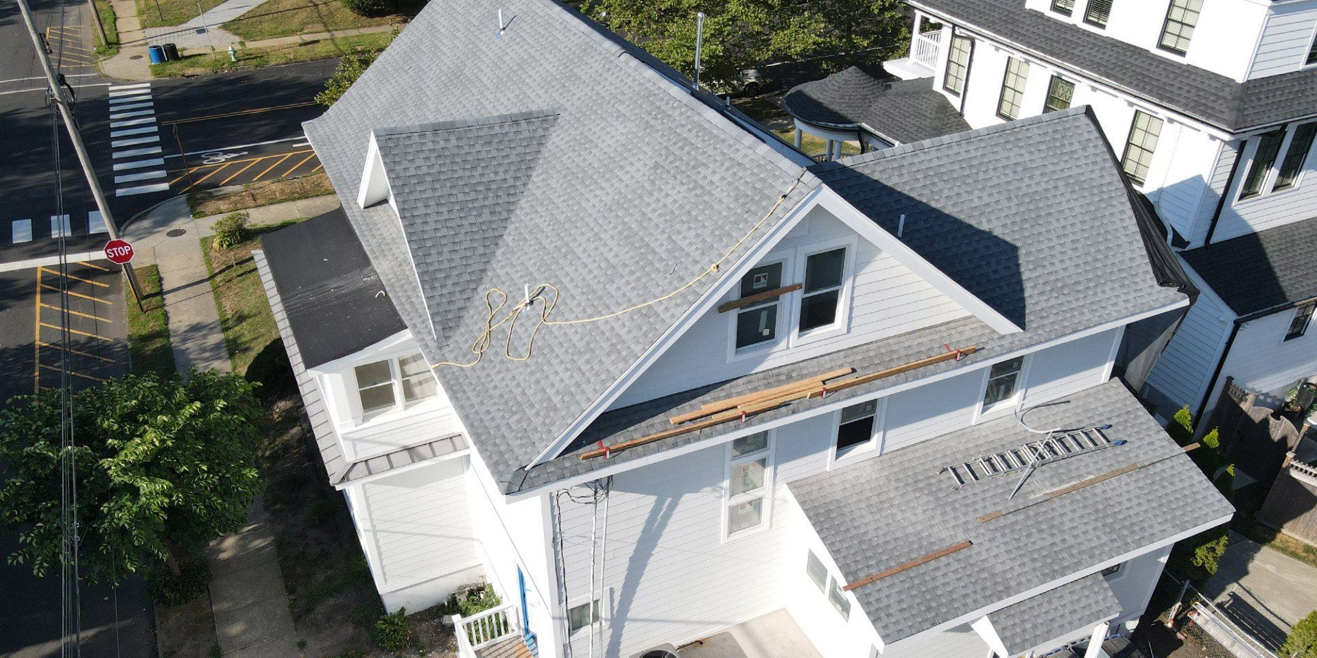 An aerial view of a white house with a gray roof.