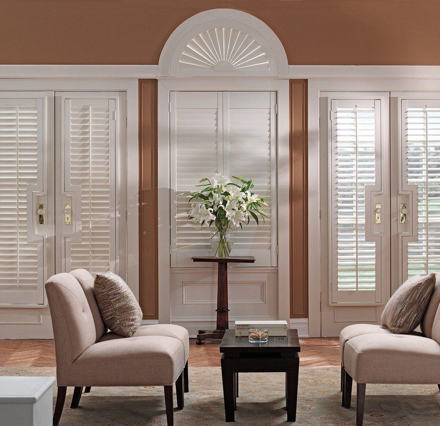 A living room with two chairs and a table with a vase of flowers on it
