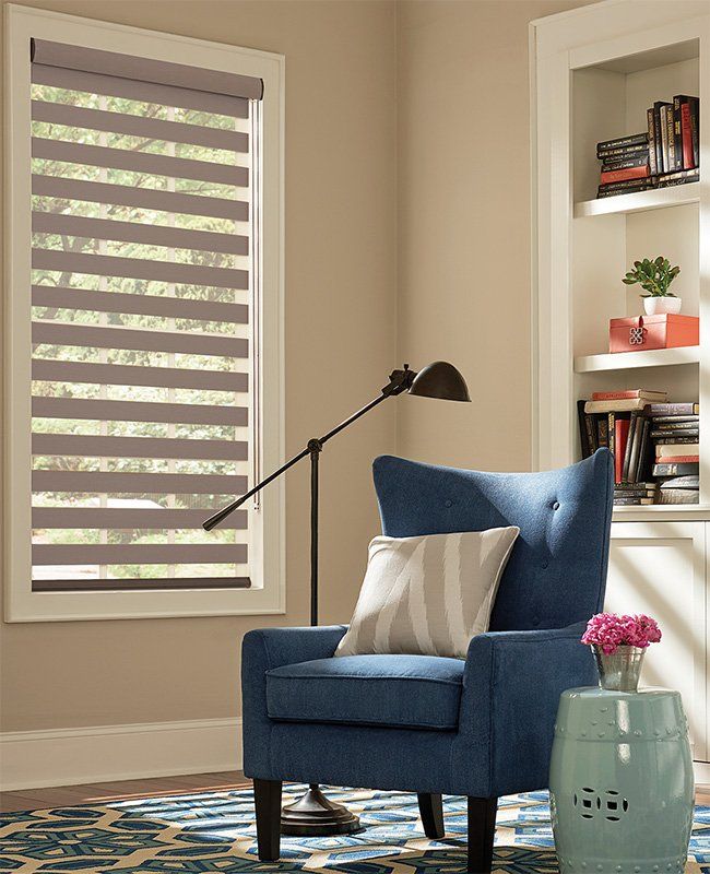 A living room with a blue chair and a lamp