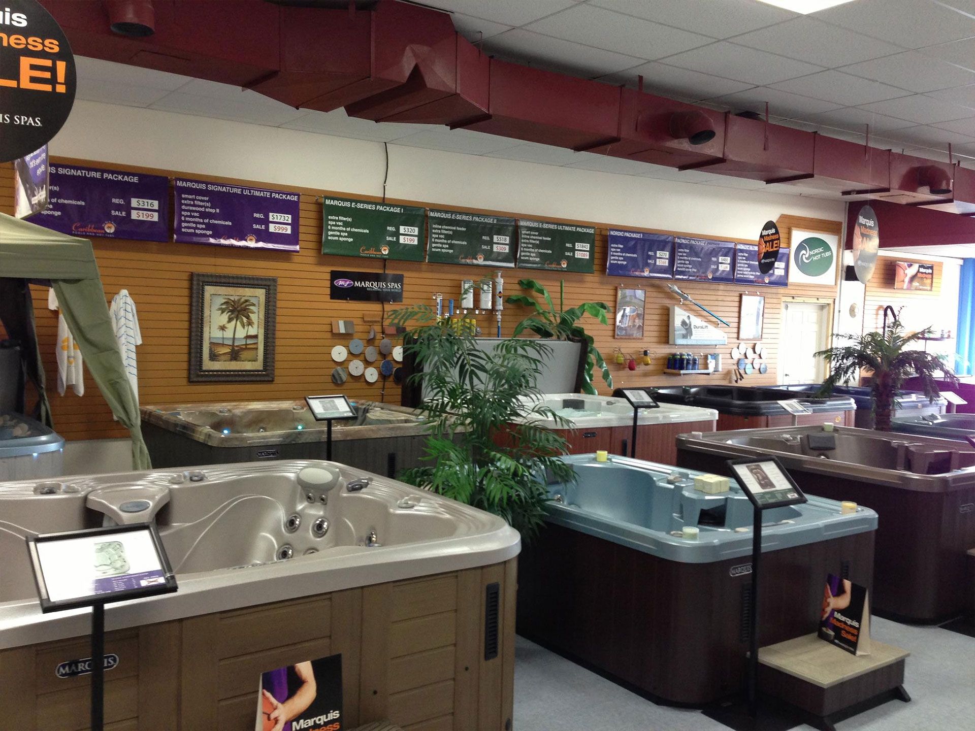 Indoor showroom with several hot tubs on display.