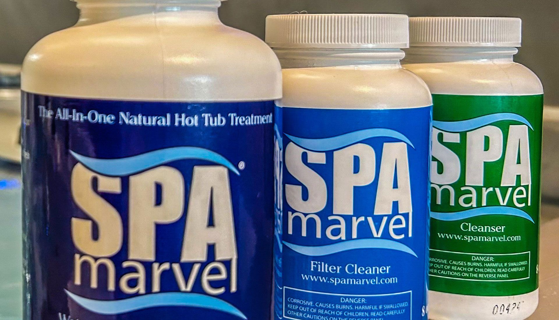 Three Spa Marvel bottles: The All-In-One Natural Hot Tub Treatment, Filter Cleaner, and Spa Cleaner, all with blue and white labels.
