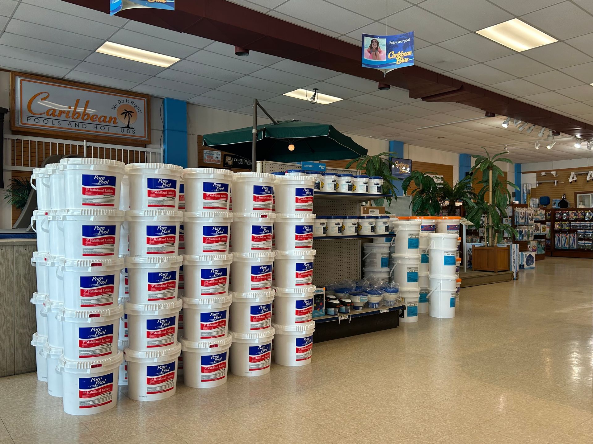 Rows of white buckets with blue and red labels stacked in a store.