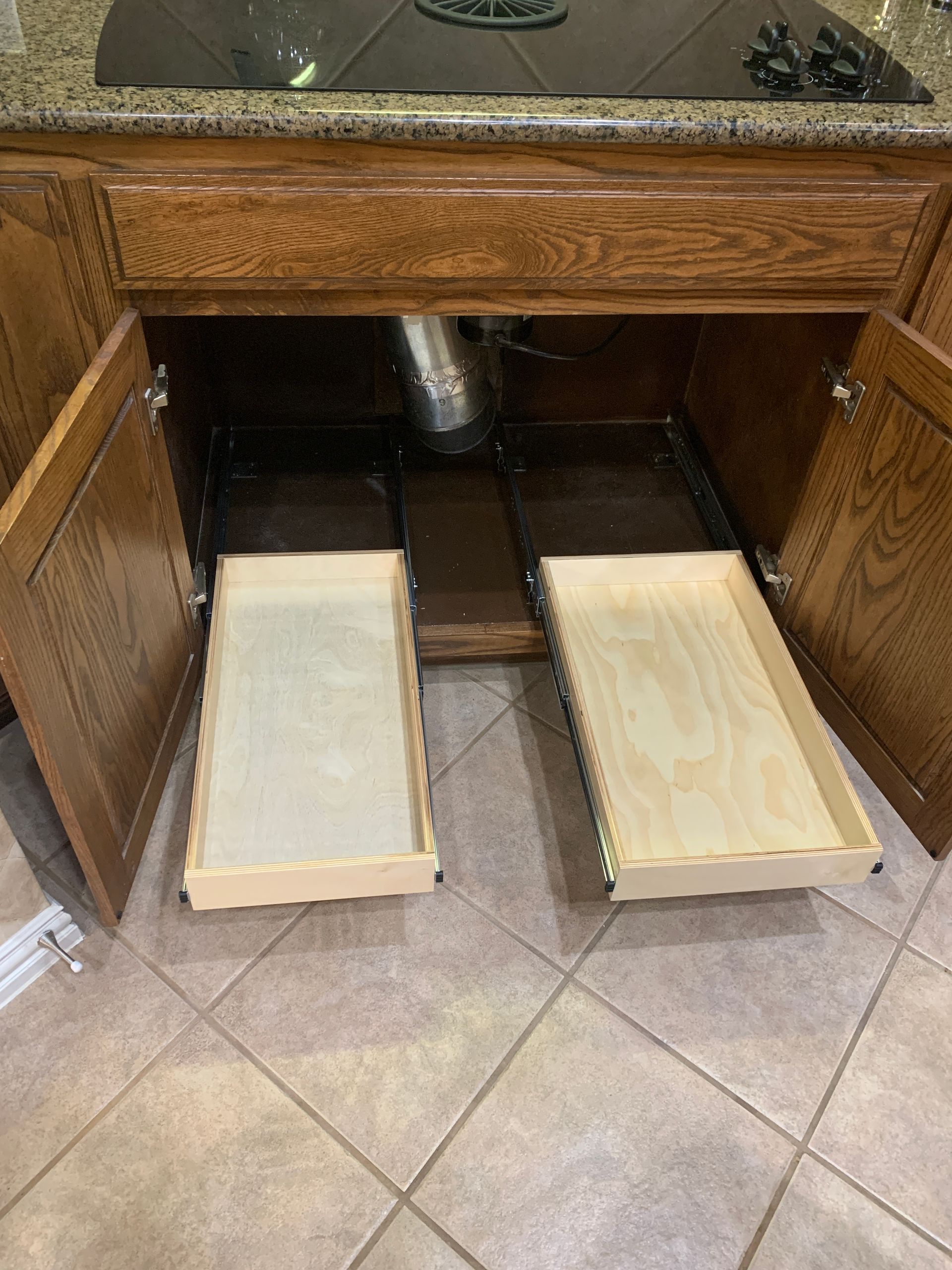 Kitchen cabinet with pull-out drawers. Wooden drawers with light-colored wood in a brown cabinet.
