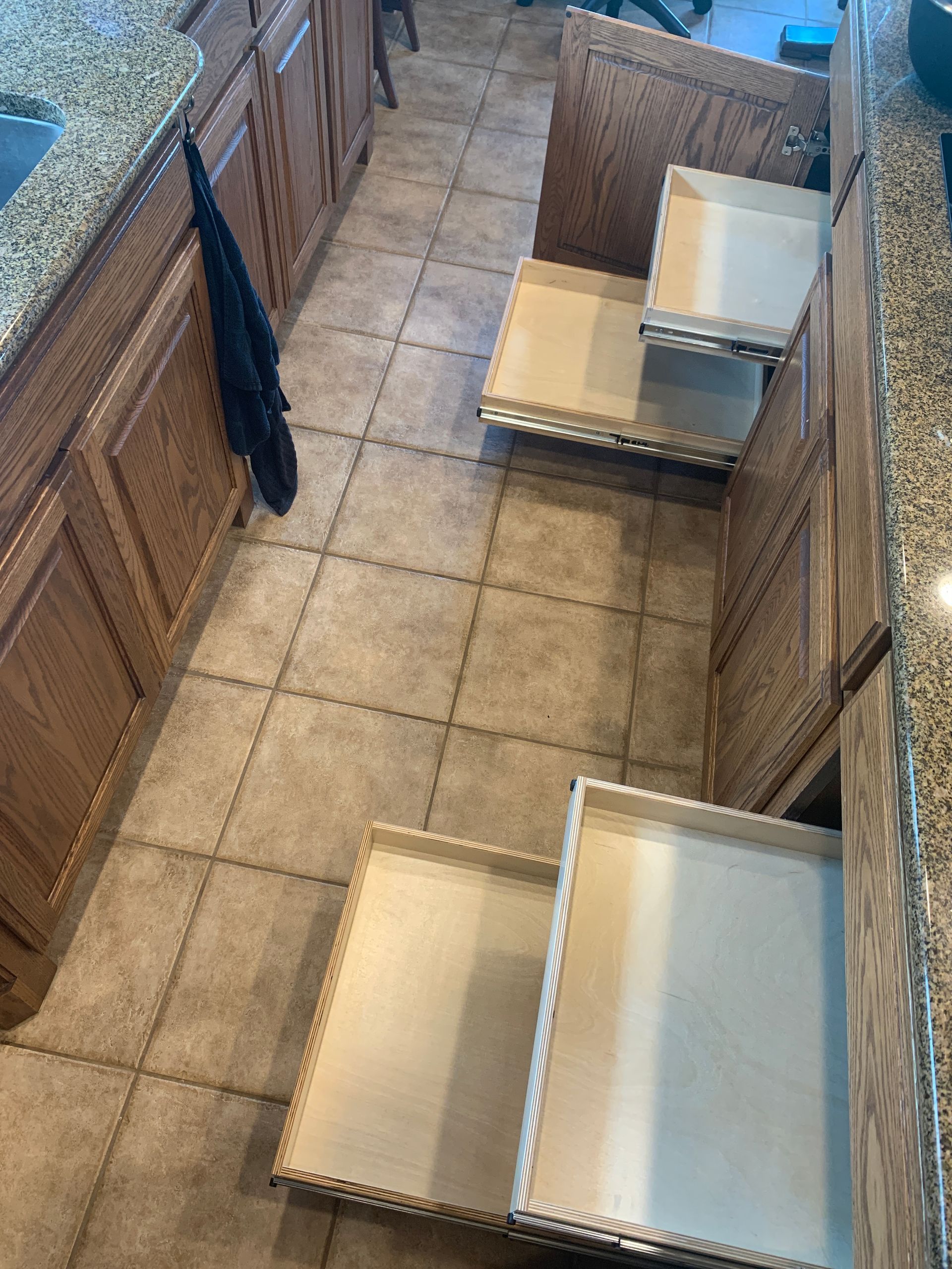 Kitchen cabinets with several drawers pulled out, showing interior shelves.