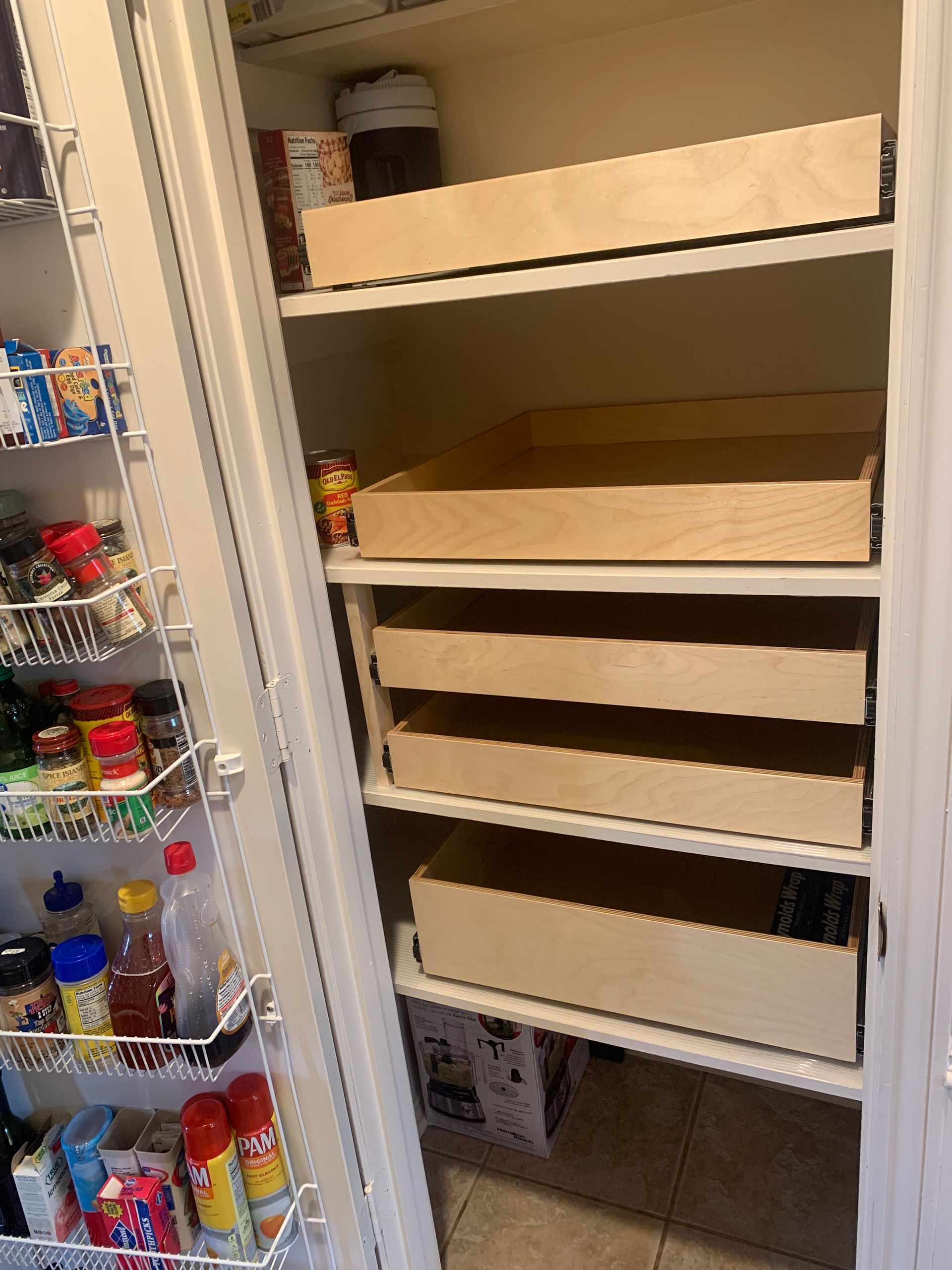 Pantry with pull-out wooden shelves installed. Left side has wire shelves holding various food items.