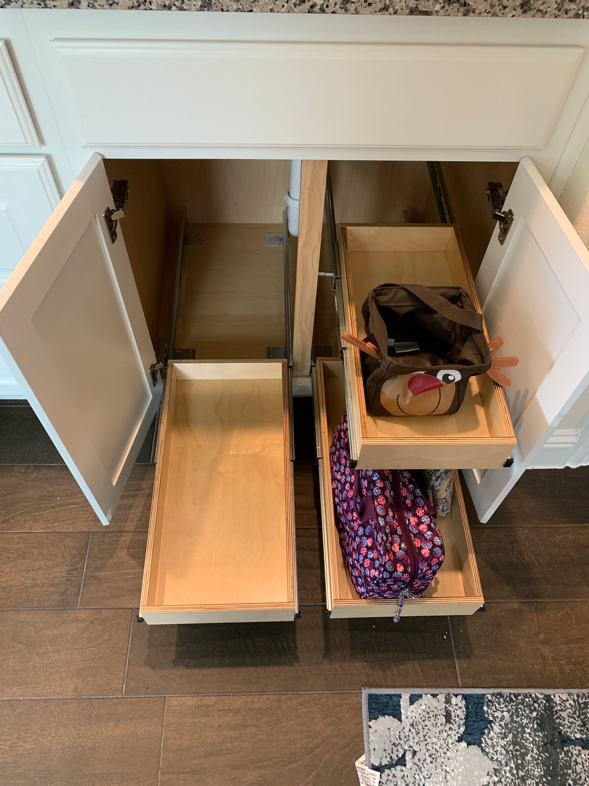 White cabinet with open doors reveals pull-out drawers on the right and a stationary shelf on the left.