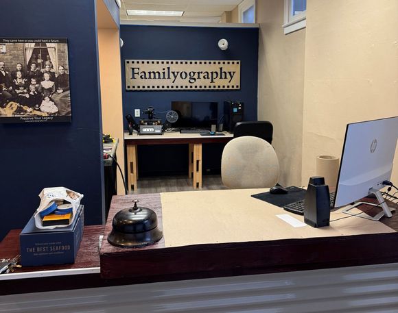 A desk with a computer and a sign that says familyography