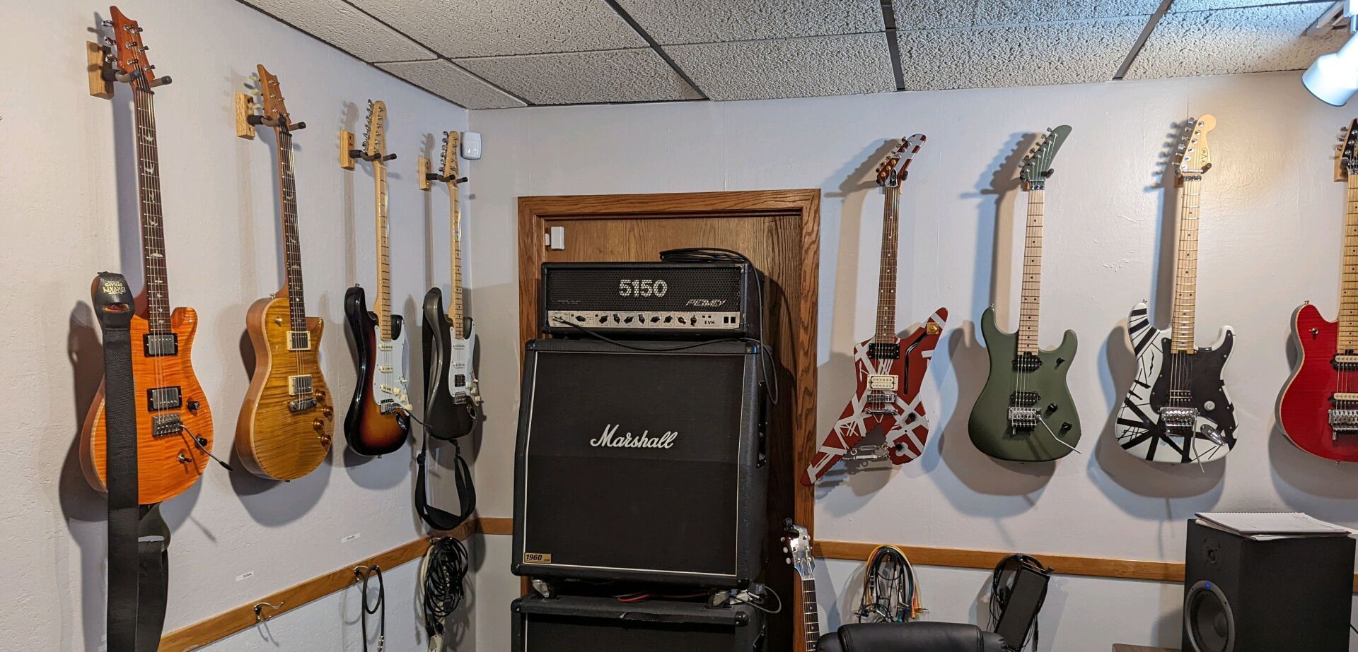Large amp and guitars hanging on wall