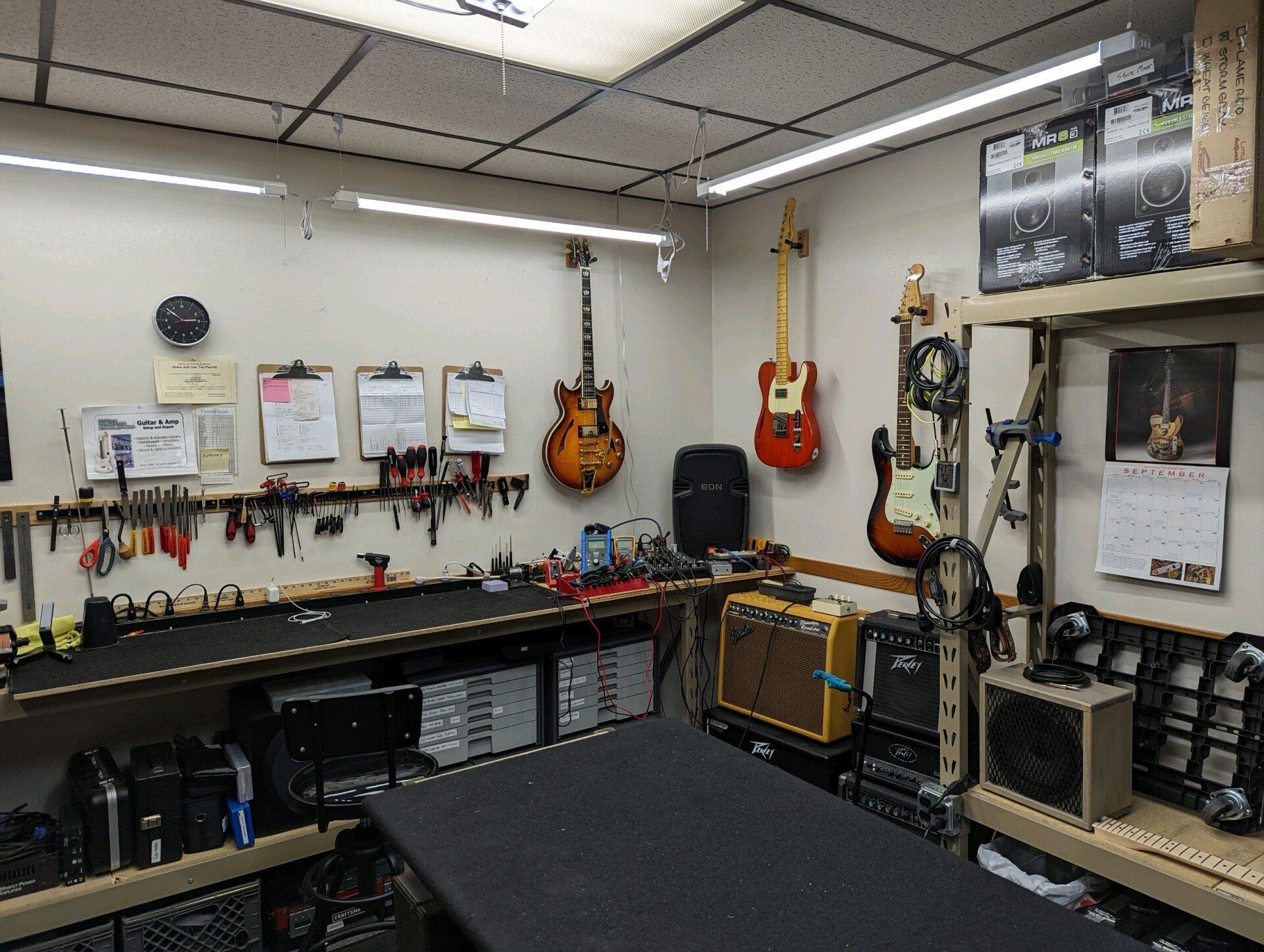 Corner of room with amps and guitars on the wall